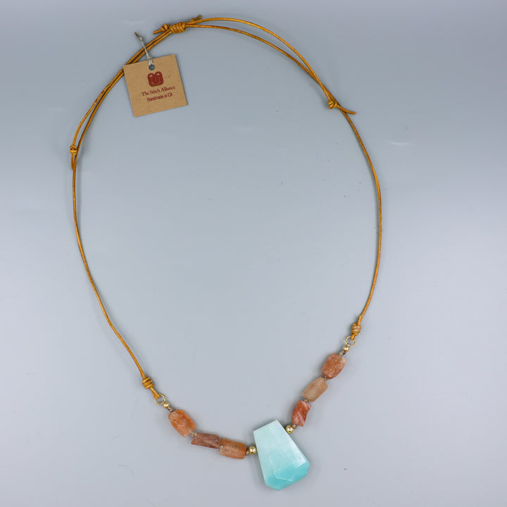adjustable leather handmade amazonite, sunstone, and gold fill necklace on a gray background