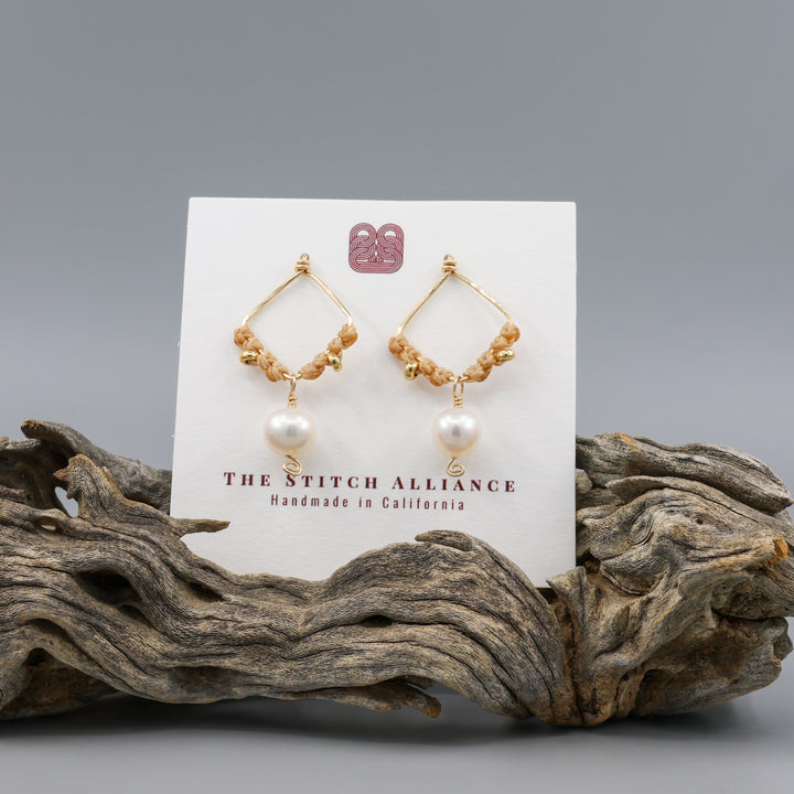 handmade square shaped gold macrame earrings with freshwater pearl beads on a white card