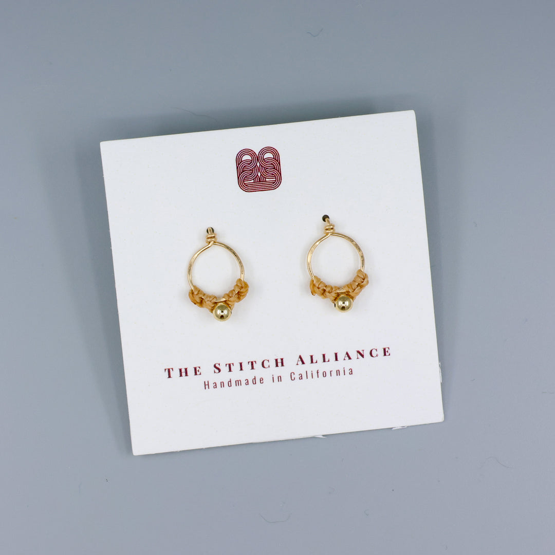 handmade gold macrame stud earrings on a white card