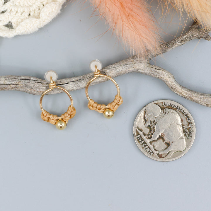 handmade gold macrame stud earrings with a nickel for size comparison
