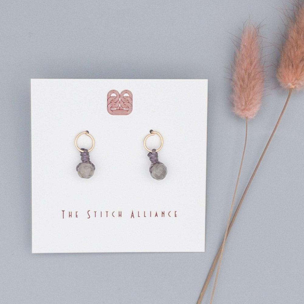 14k gold filled circle post earrings with a labradorite bead on a gray background