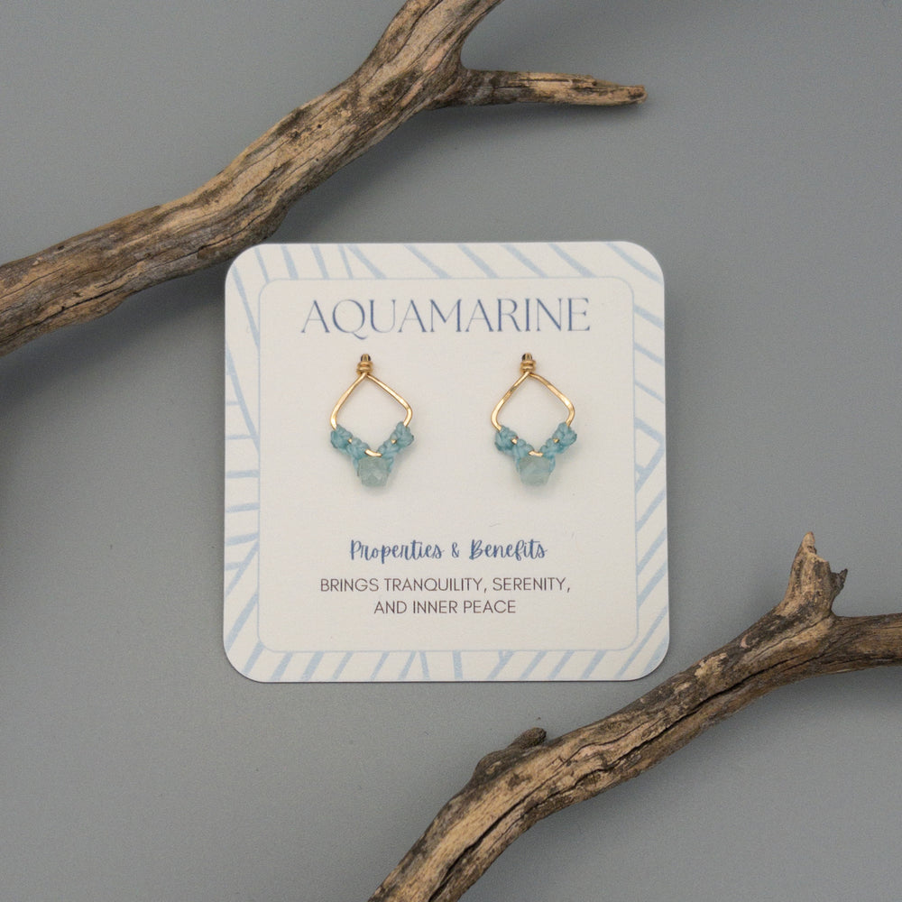 handmade aquamarine earrings with properties and benefits of aquamarine on the card. gift earrings on a gray background