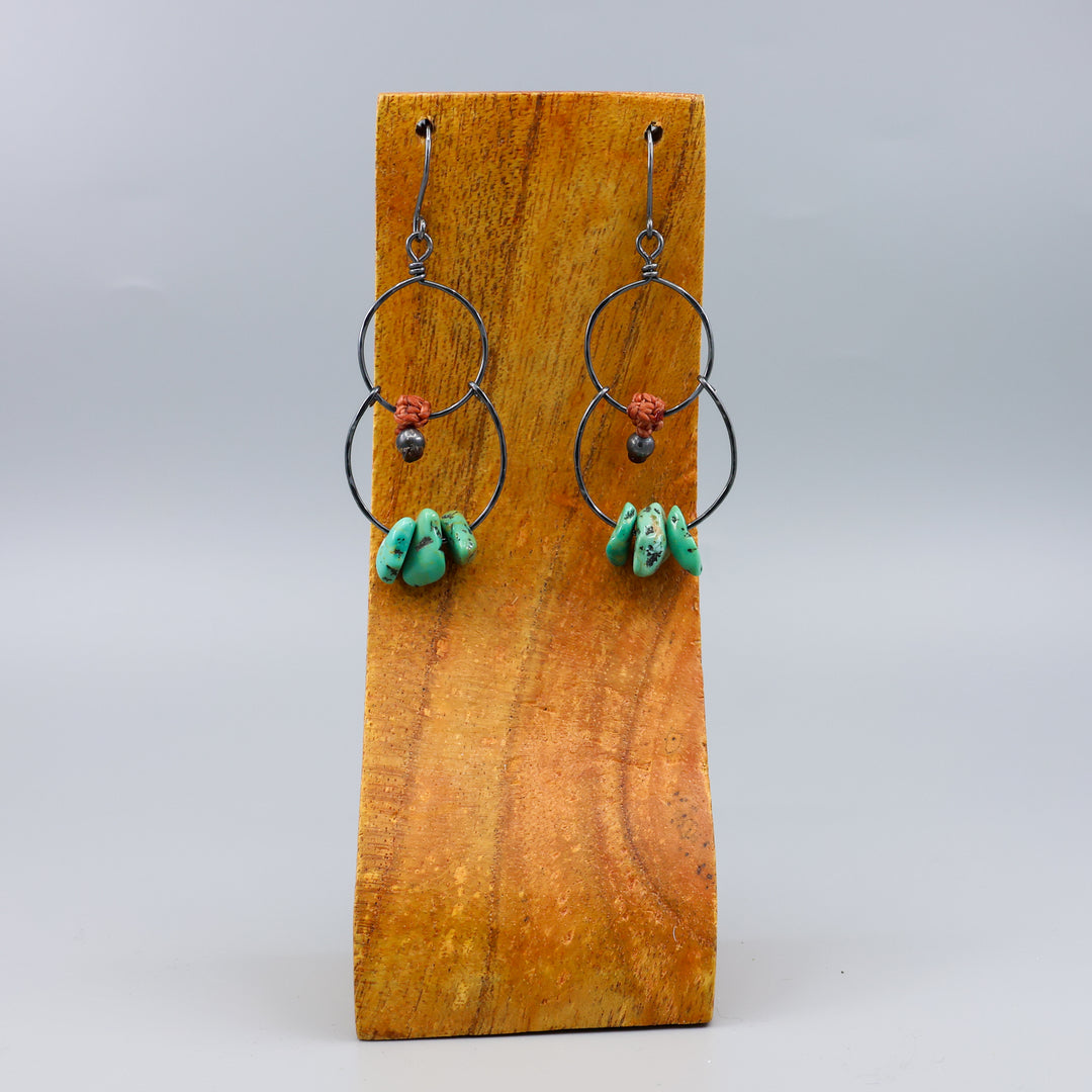 handmade double hoop earrings with turquoise beads and oxidized sterling silver on a wood display