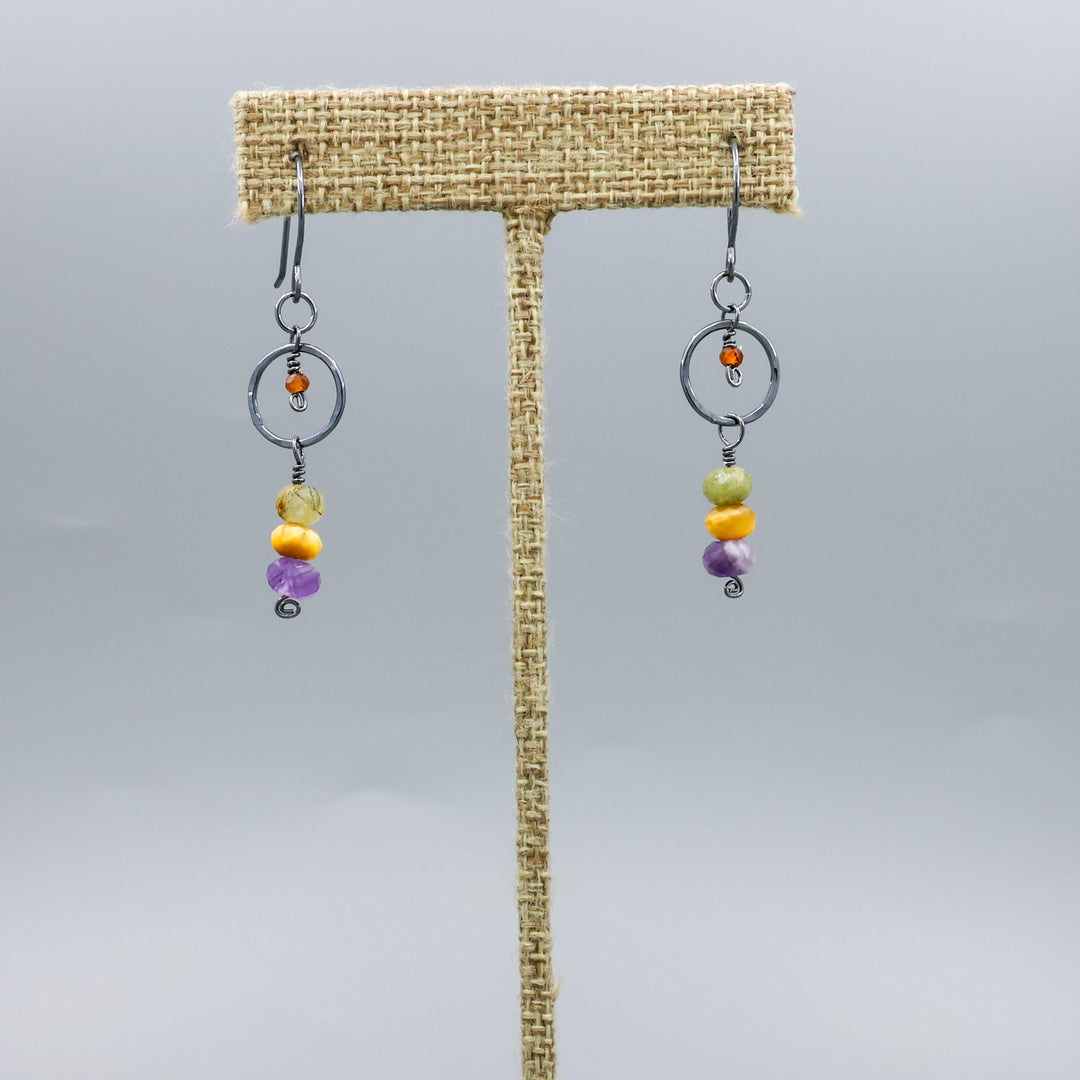 handmade oxidized sterling silver, amethyst, golden tigers eye, green garnet, and hessonite dangle earrings on a linen hanger