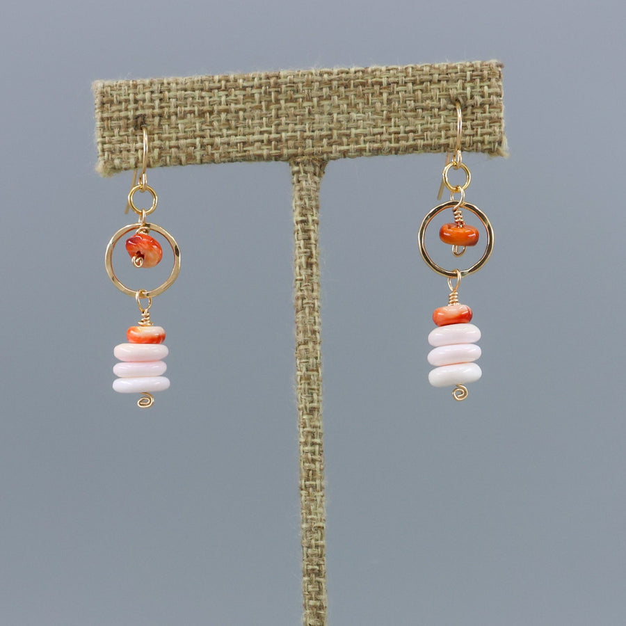queen conch and spiny oyster gold fill earrings shown on a linen display hanger