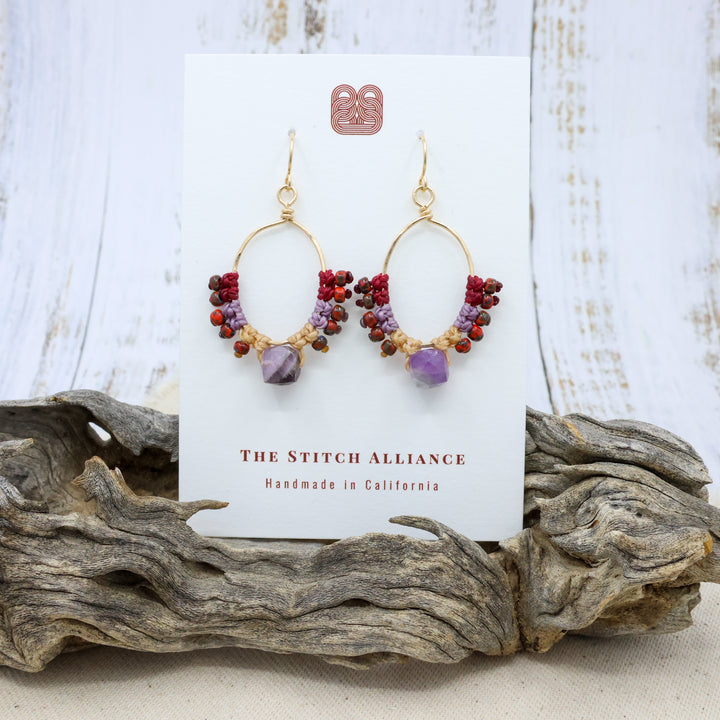 handmade 14k gold filled hoops with macrame and an amethyst bead on a white card