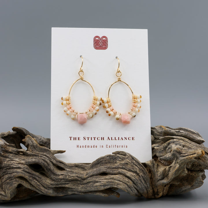 handmade gold macrame hoop earrings with a pink opal bead on a white card