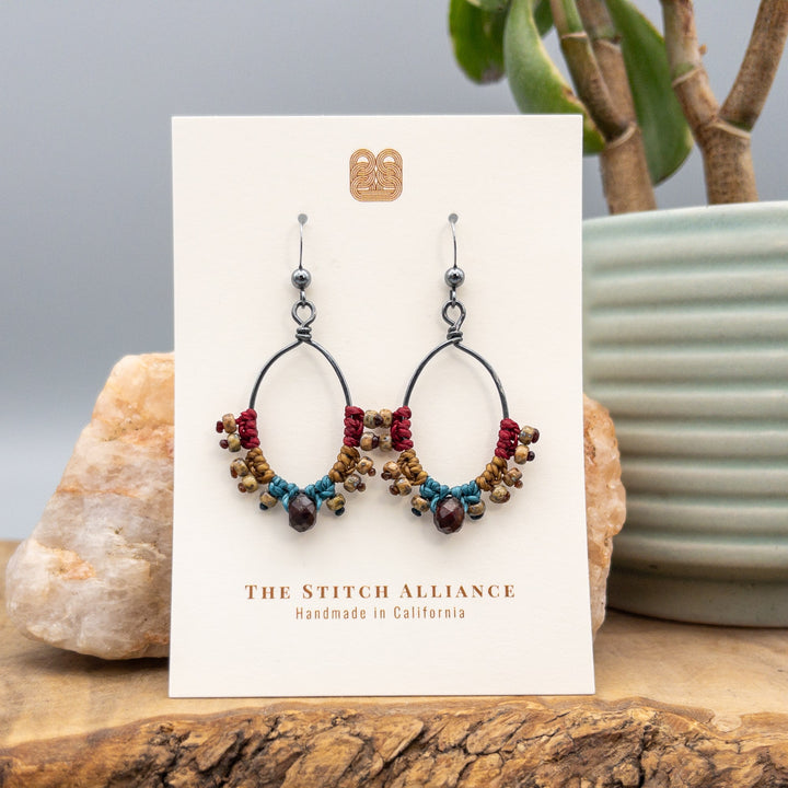 handmade macrame hoop earrings with garnet bead on a white card