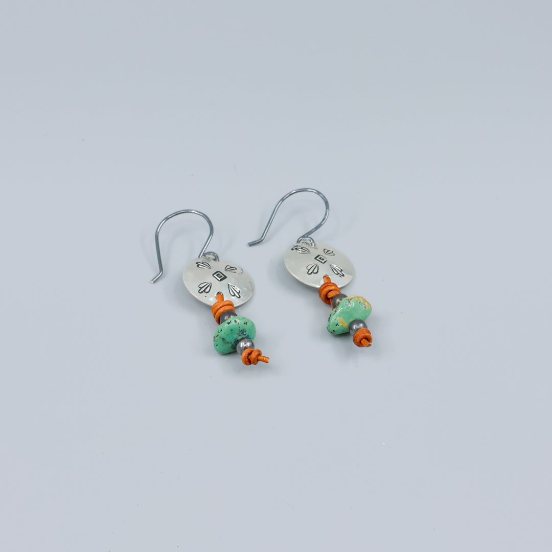 turquoise and stamped sterling silver earrings on gray background
