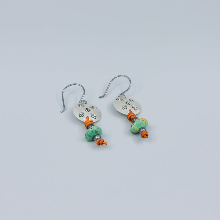 turquoise and stamped sterling silver earrings on gray background