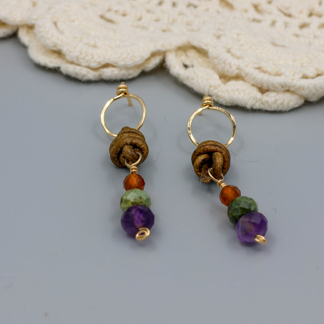 handmade amethyst, green garnet, and hessonite leather and gold fill earrings close up
