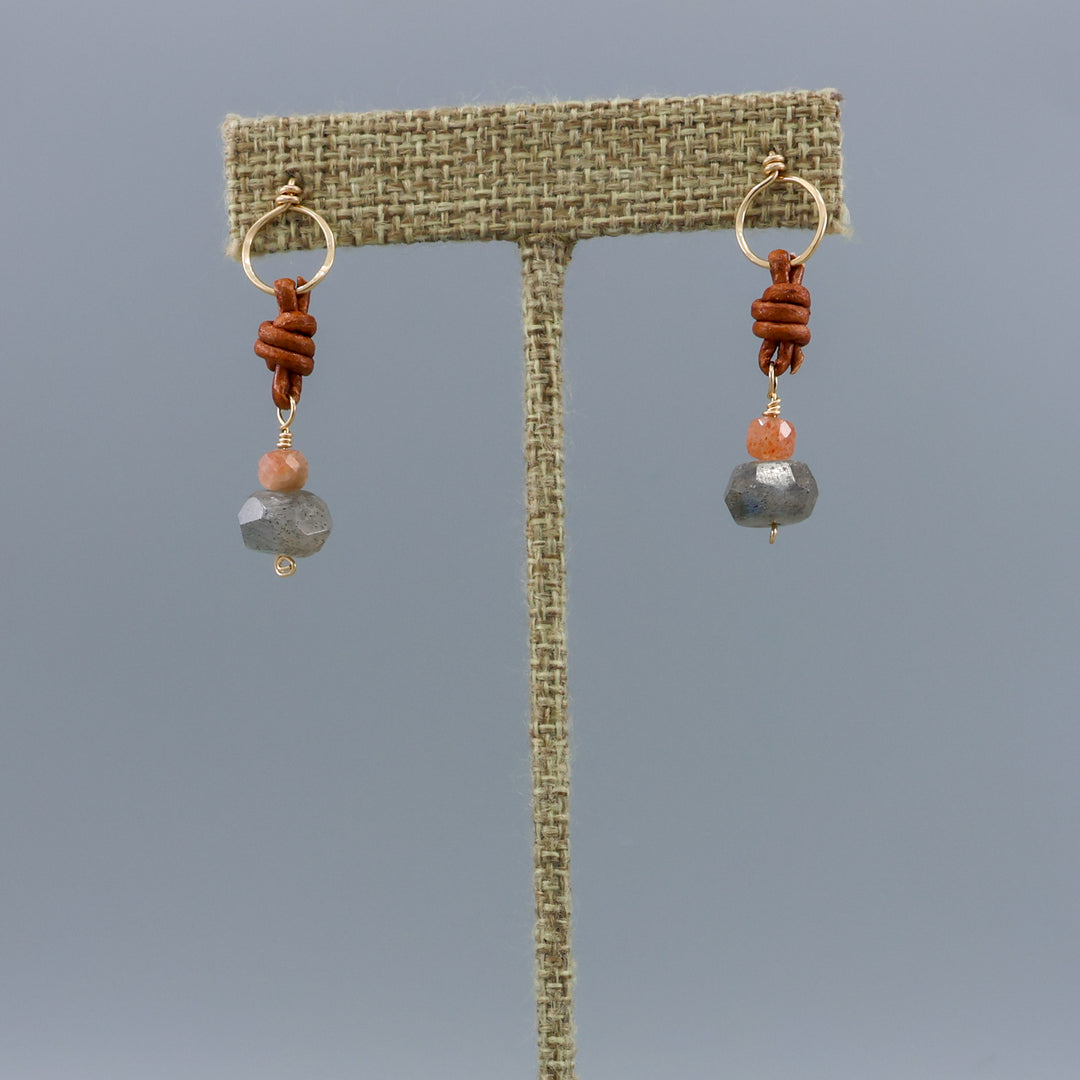 labradorite, sunstone, gold fill, and leather handmade drop earrings on a linen hanger