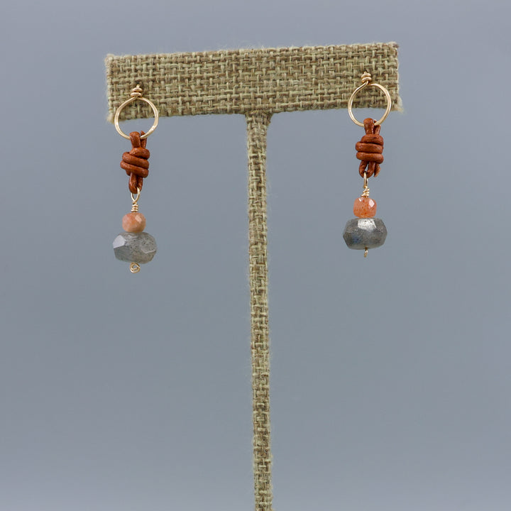 labradorite, sunstone, gold fill, and leather handmade drop earrings on a linen hanger
