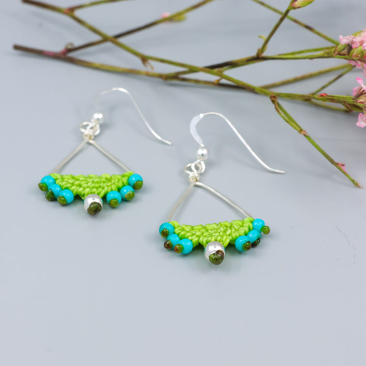 detail view of handmade sterling silver triangle hoop earrings with lime green macrame