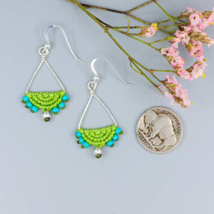 handmade sterling silver triangle hoop earrings with lime green macrame with a nickel for size comparison