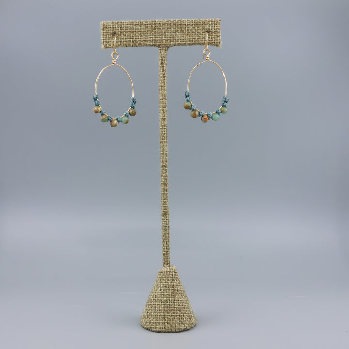 handmade gold hoop macrame earrings with aqua terra jasper beads on a linen hanger