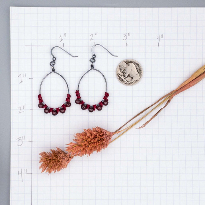 garnet oval hoop earrings in oxidized sterling silver on graph paper for size comparison