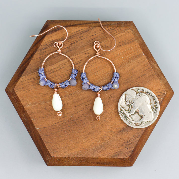 Rose gold and mother of pearl hoop earrings shown with a coin for size comparison