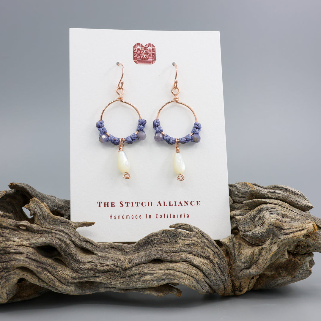 Rose gold and mother of pearl hoop earrings shown on a white card