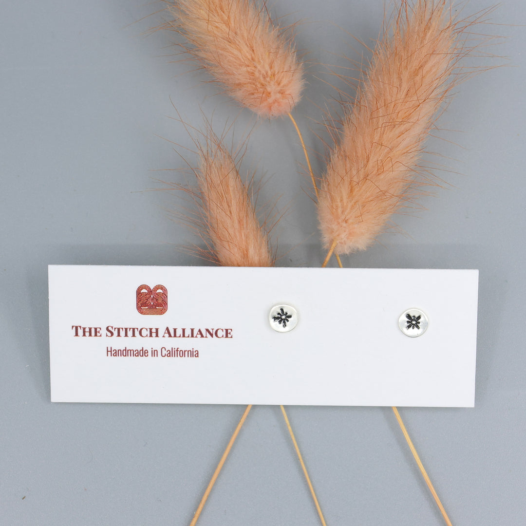 starburst silver stamped minimalist earrings on a white card