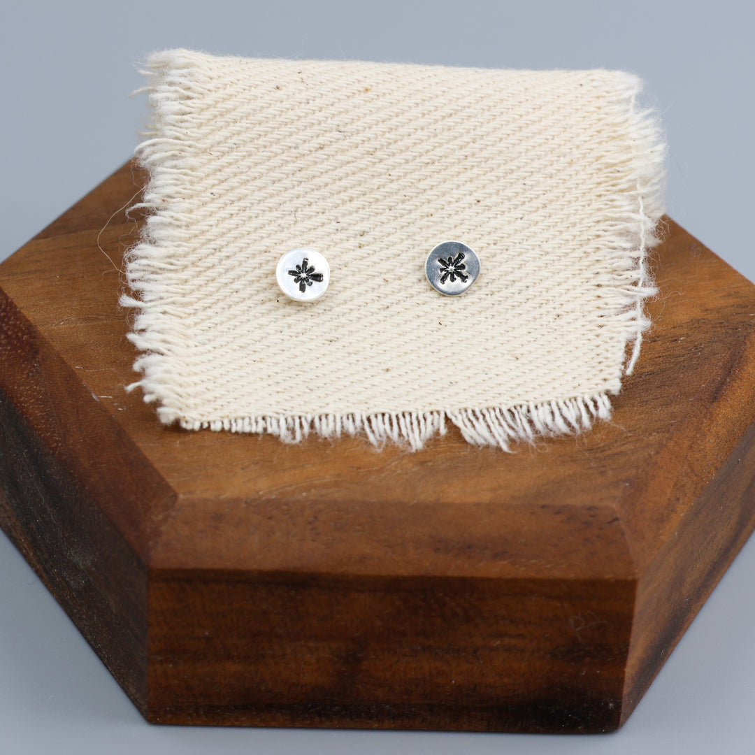 starburst silver stamped minimalist earrings on muslin fabric