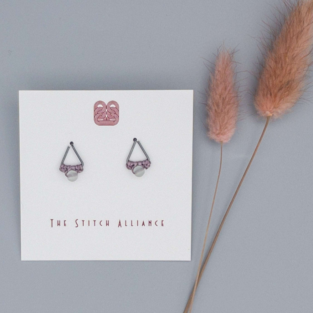 oxidized sterling silver triangle shaped post-style earring with rainbow fluorite bead on a gray background