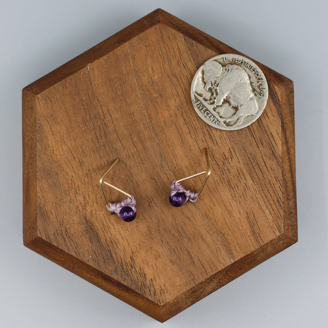 handmade gold fill amethyst triangle stud earrings with a nickel for size comparison
