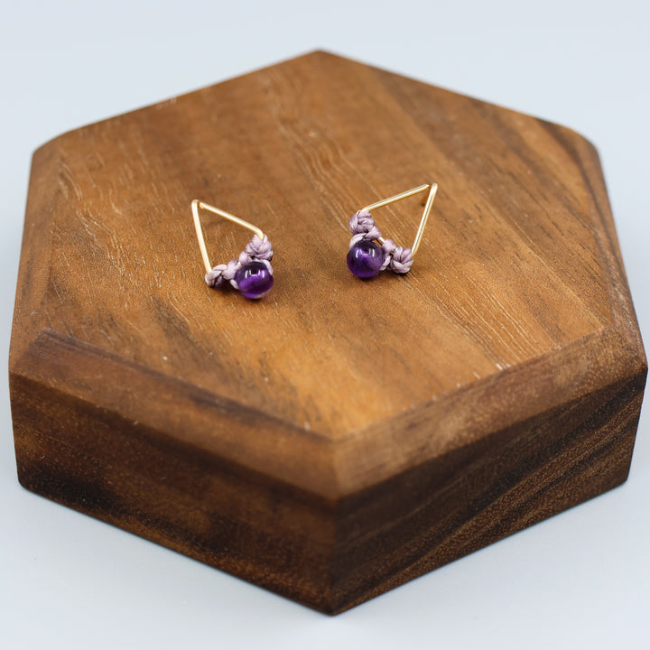 handmade gold fill amethyst triangle stud earrings on a wood display