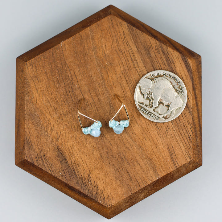handmade gold filled triangle stud earrings with aquamarine beads with a nickel for size comparison