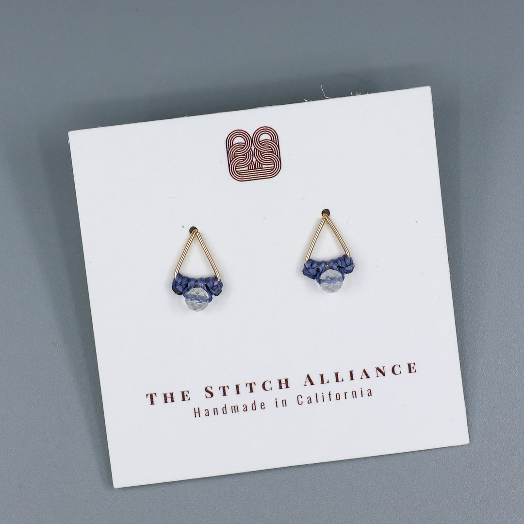 handmade gold fill  triangle stud earrings with a clear quartz beads on a white card with gray background