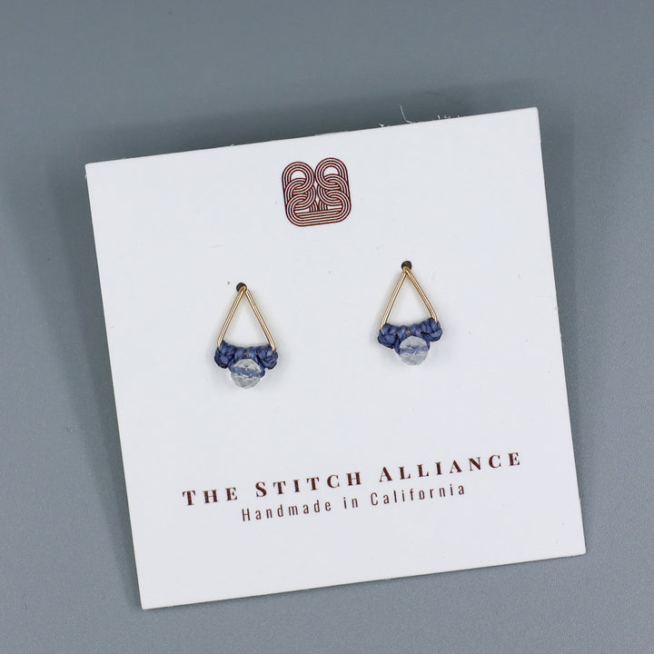 handmade gold fill  triangle stud earrings with a clear quartz beads on a white card with gray background