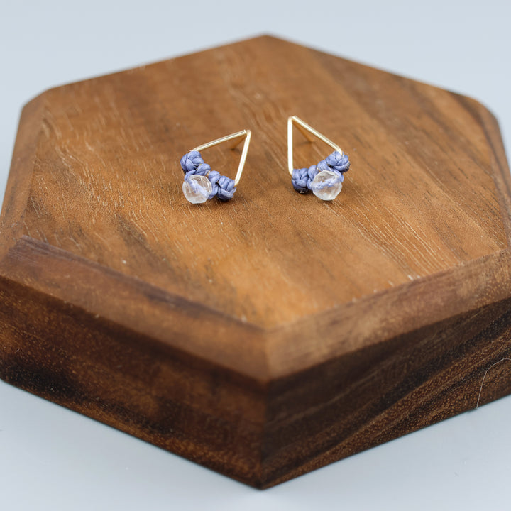 handmade gold fill  triangle stud earrings with a clear quartz beads on a wood display