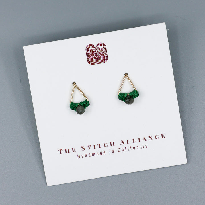 handmade gold fill  triangle stud earrings with emerald beads on a white card on a gray background