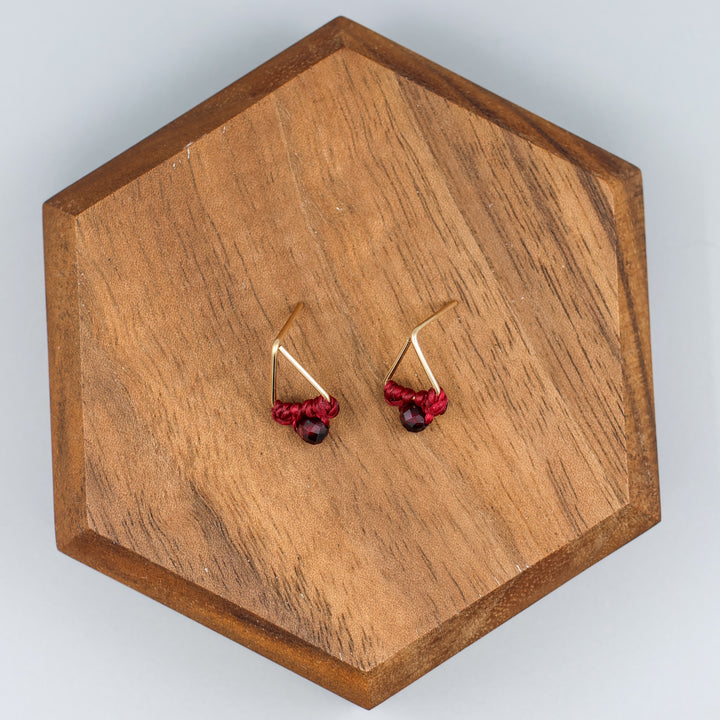 handmade gold filled triangle stud earrings with garnet beads overhead view