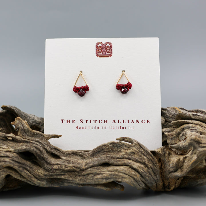 handmade gold filled triangle stud earrings with garnet beads on a white card