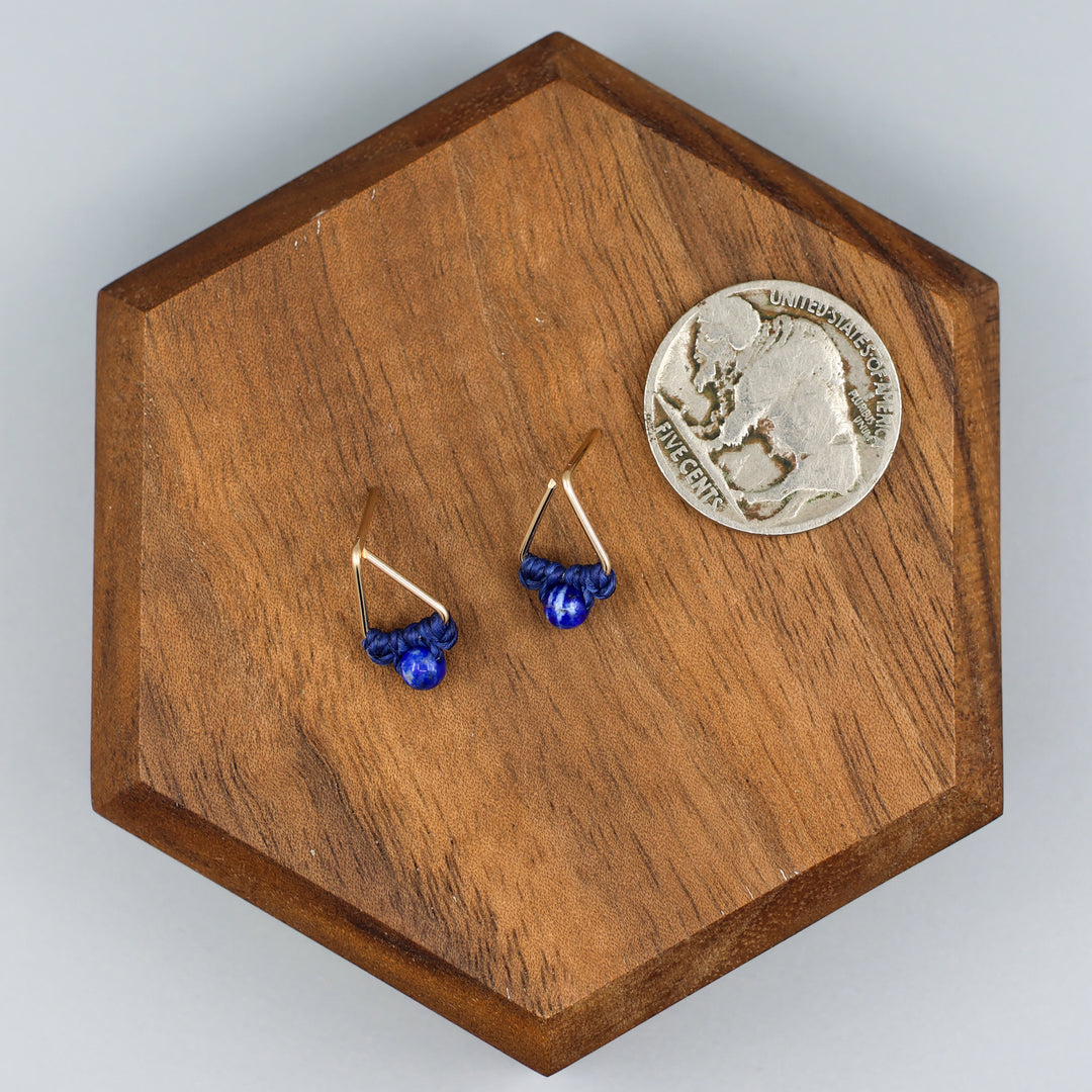 handmade triangle shaped earrings in gold fill with a lapis lazuli bead with a nickel for size comparison