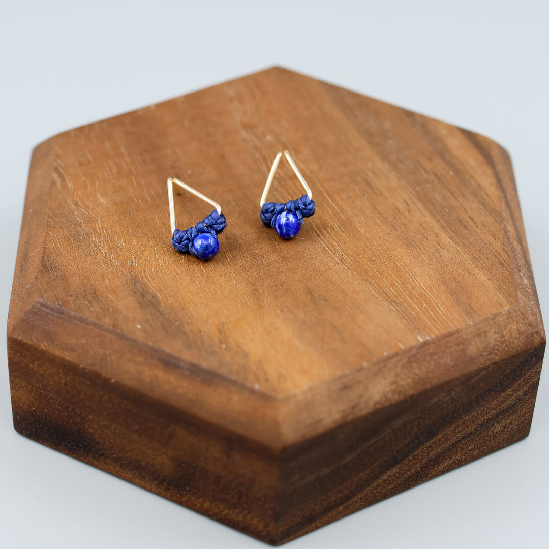 handmade triangle shaped earrings in gold fill with a lapis lazuli bead overhead view