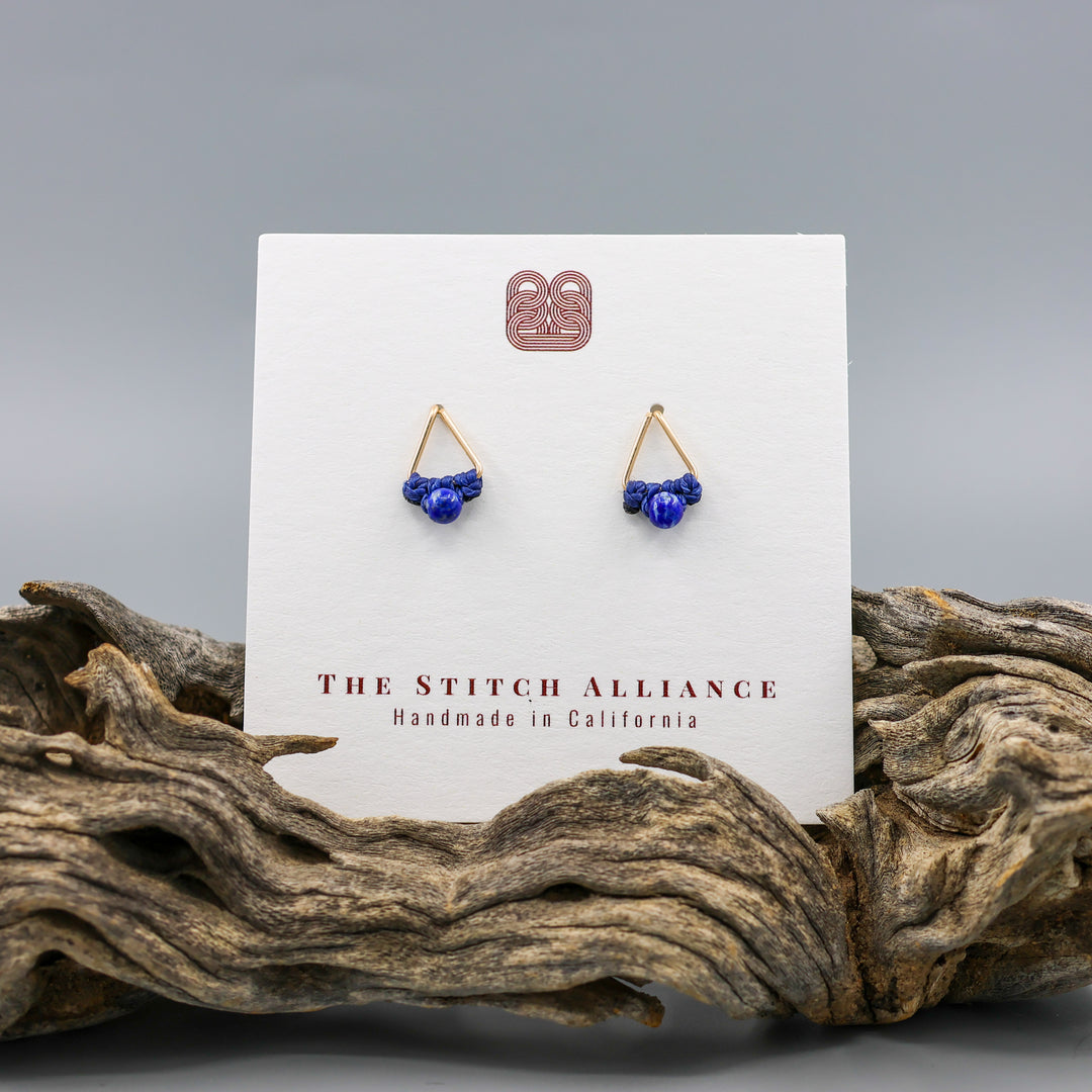 handmade triangle shaped earrings in gold fill with a lapis lazuli bead on a white card