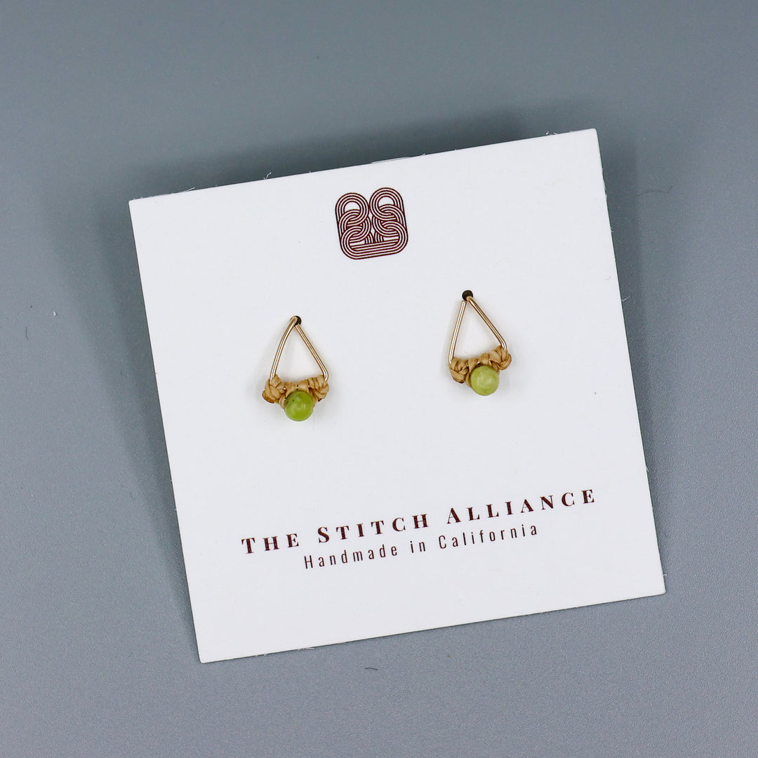 handmade gold fill  triangle stud earrings with peridot beads on a white card and gray background