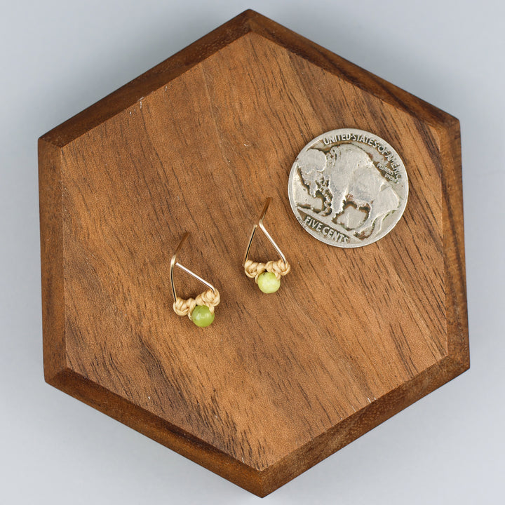 handmade gold fill  triangle stud earrings with peridot beads with a nickel for size comparison