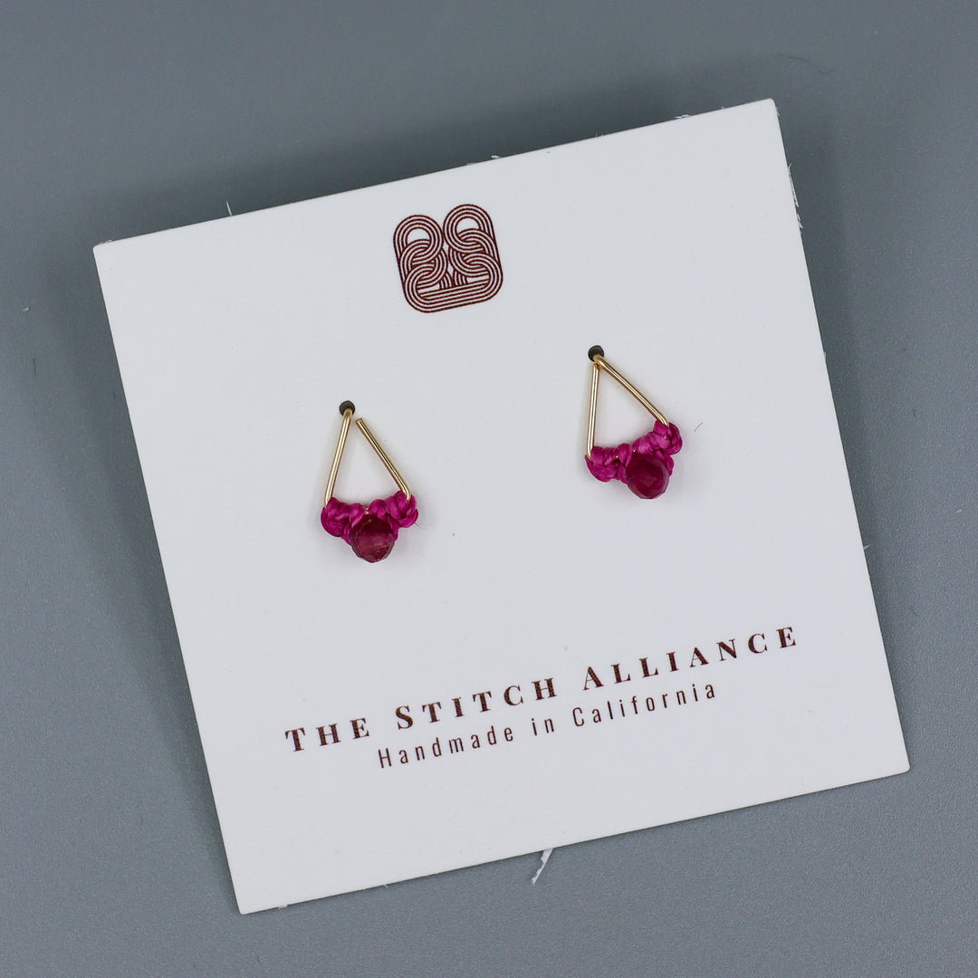 handmade gold filled triangle stud earrings with pink tourmaline beads on a white card and a gray background