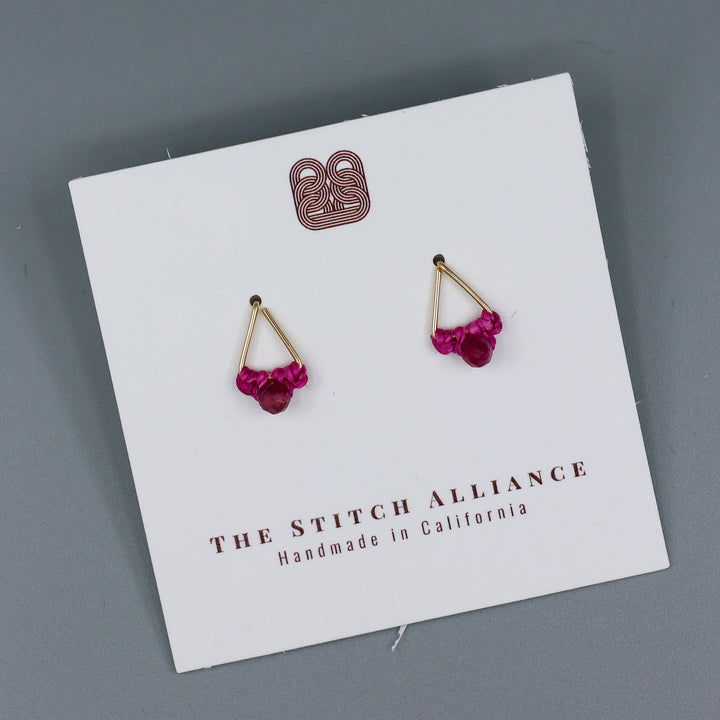 handmade gold filled triangle stud earrings with pink tourmaline beads on a white card and a gray background