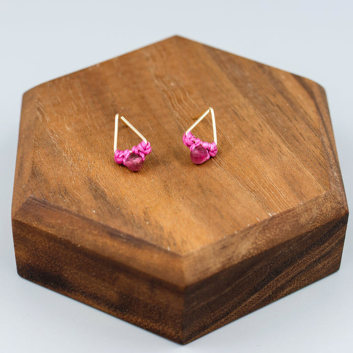 handmade gold filled triangle stud earrings with pink tourmaline beads on a wood display