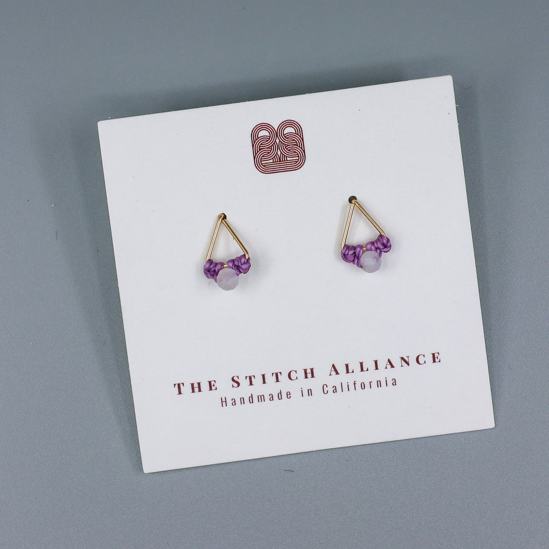 handmade triangle shaped earrings in gold fill with a rainbow moonstone bead on a white card with gray background