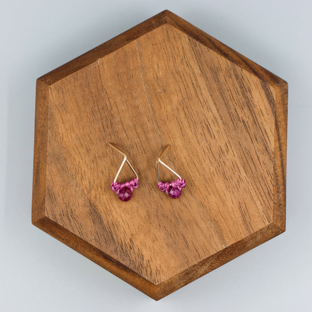 handmade gold filled triangle stud earrings with ruby beads  overhead view