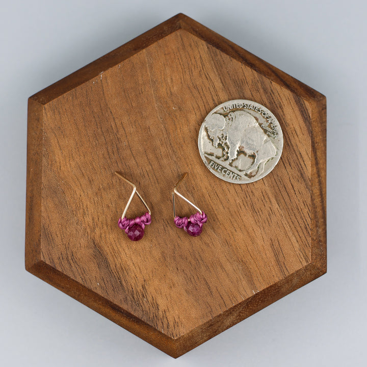 handmade gold filled triangle stud earrings with ruby beads  with a nickel for size comparison