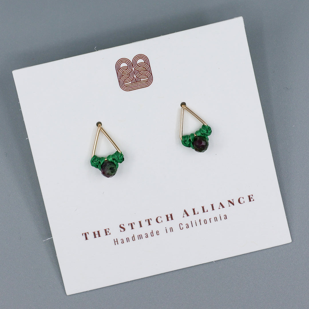 handmade gold filled triangle stud earrings with ruby zoisite beads on a white card on a gray background