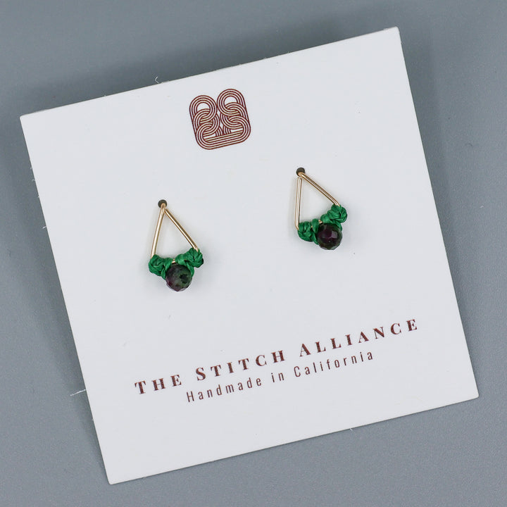 handmade gold filled triangle stud earrings with ruby zoisite beads on a white card on a gray background