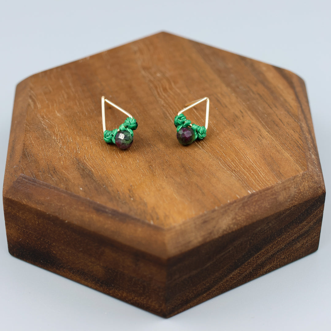 handmade gold filled triangle stud earrings with ruby zoisite beads on a wood display