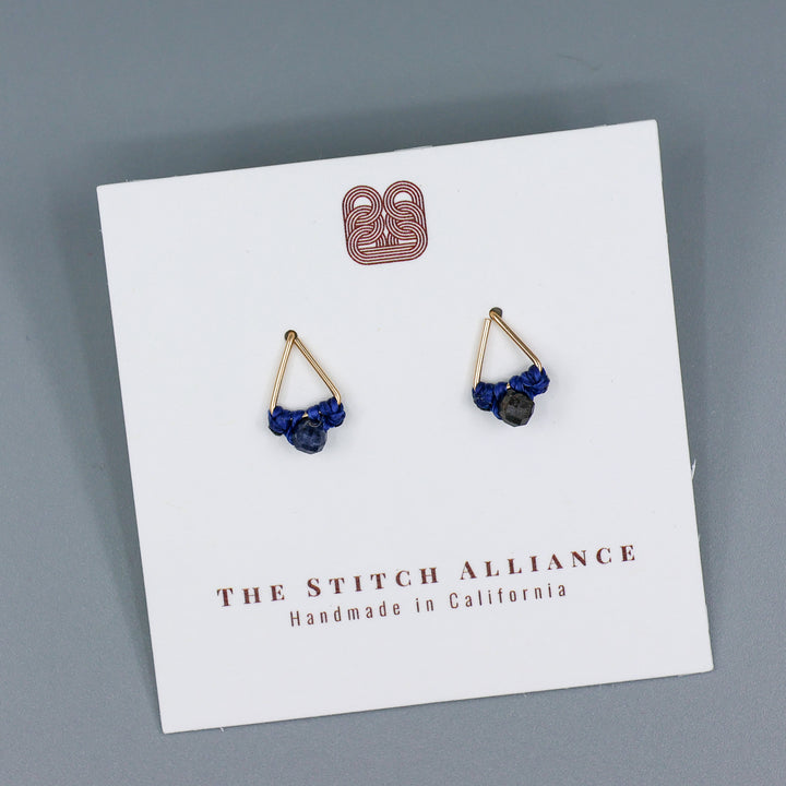 handmade gold filled triangle stud earrings with sapphire beads  on a white card with a gray background